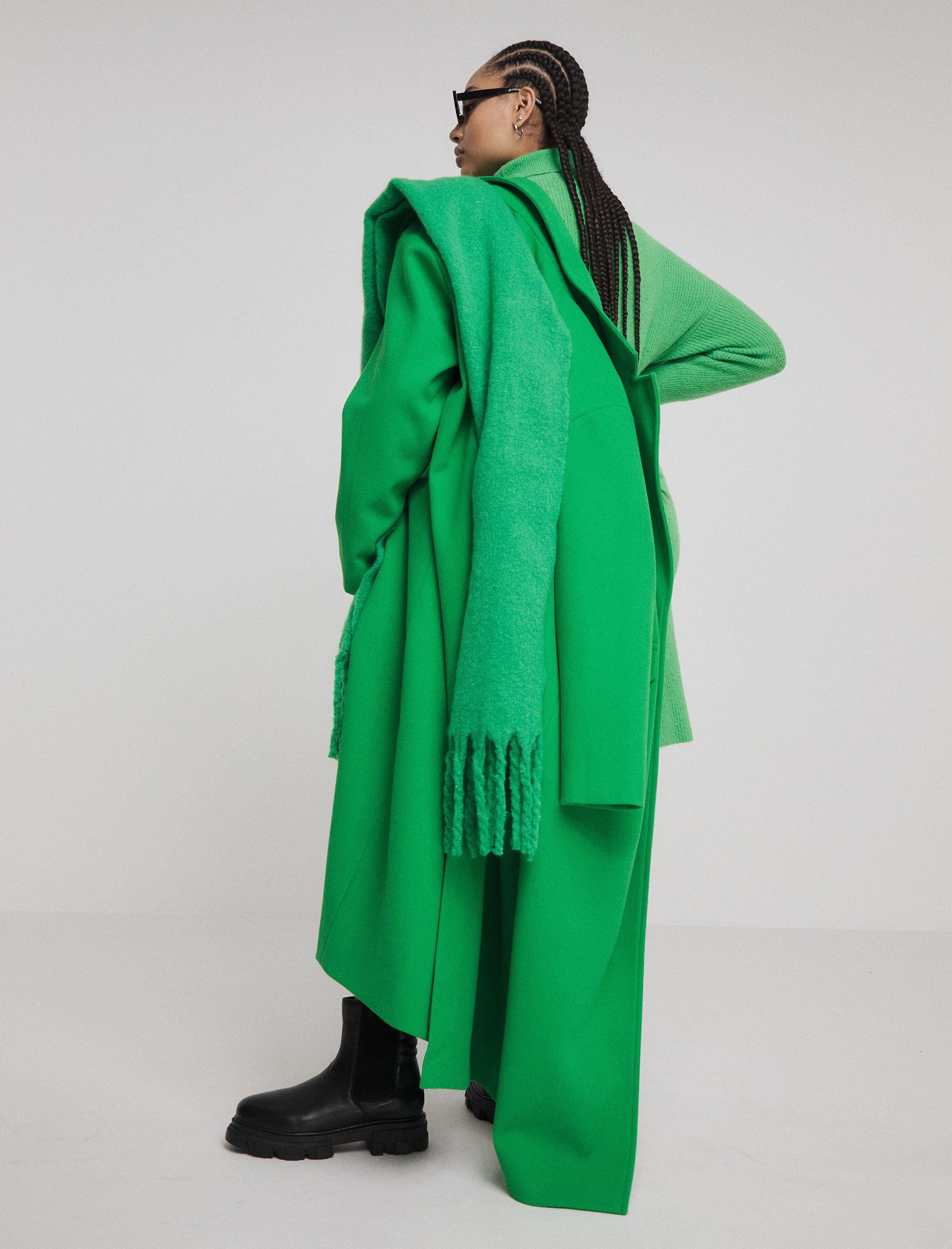 Back of model wearing green overcoat and scarf