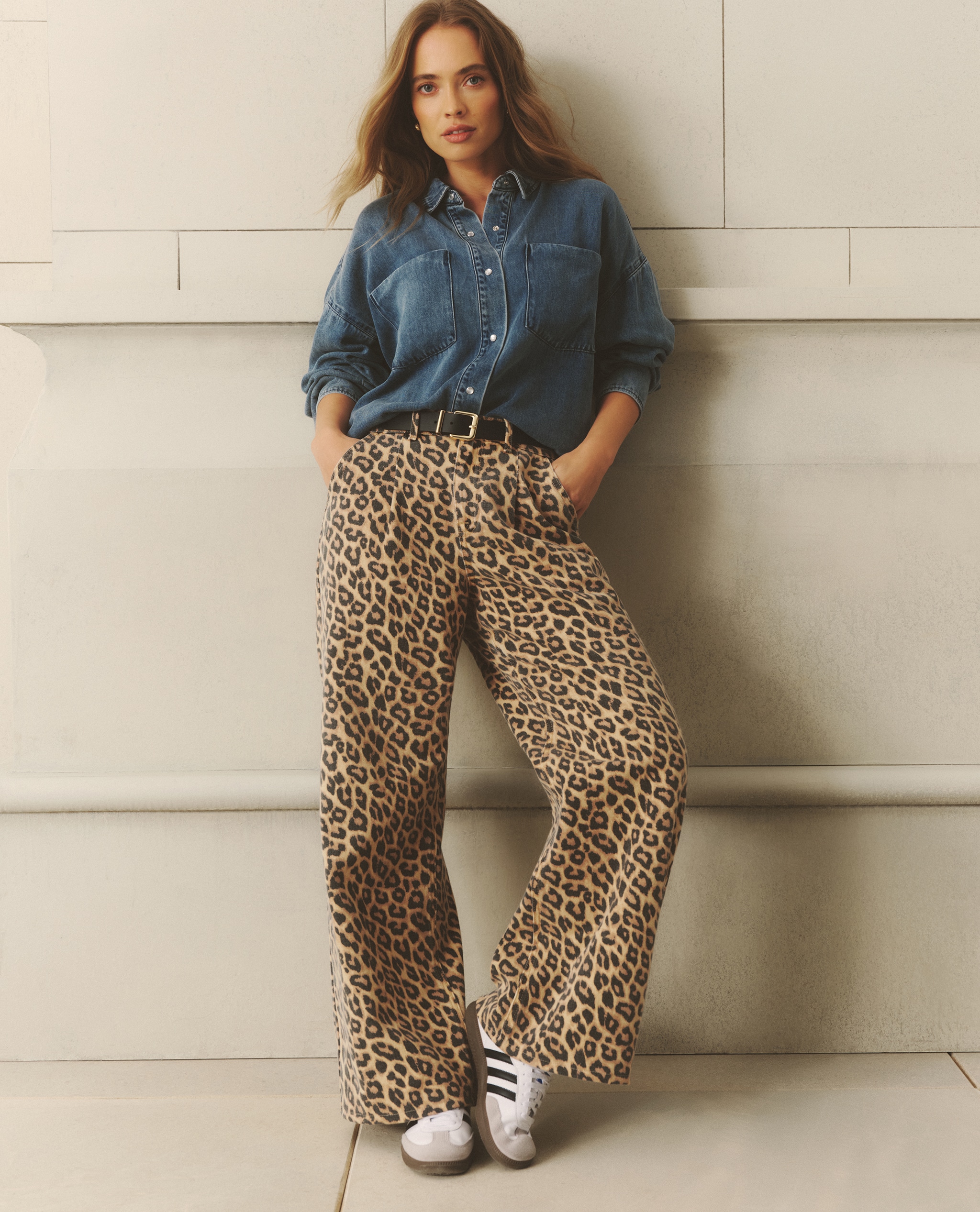 Model wearing leopard print wide leg jeans with a mid wash deep cuff denim shirt